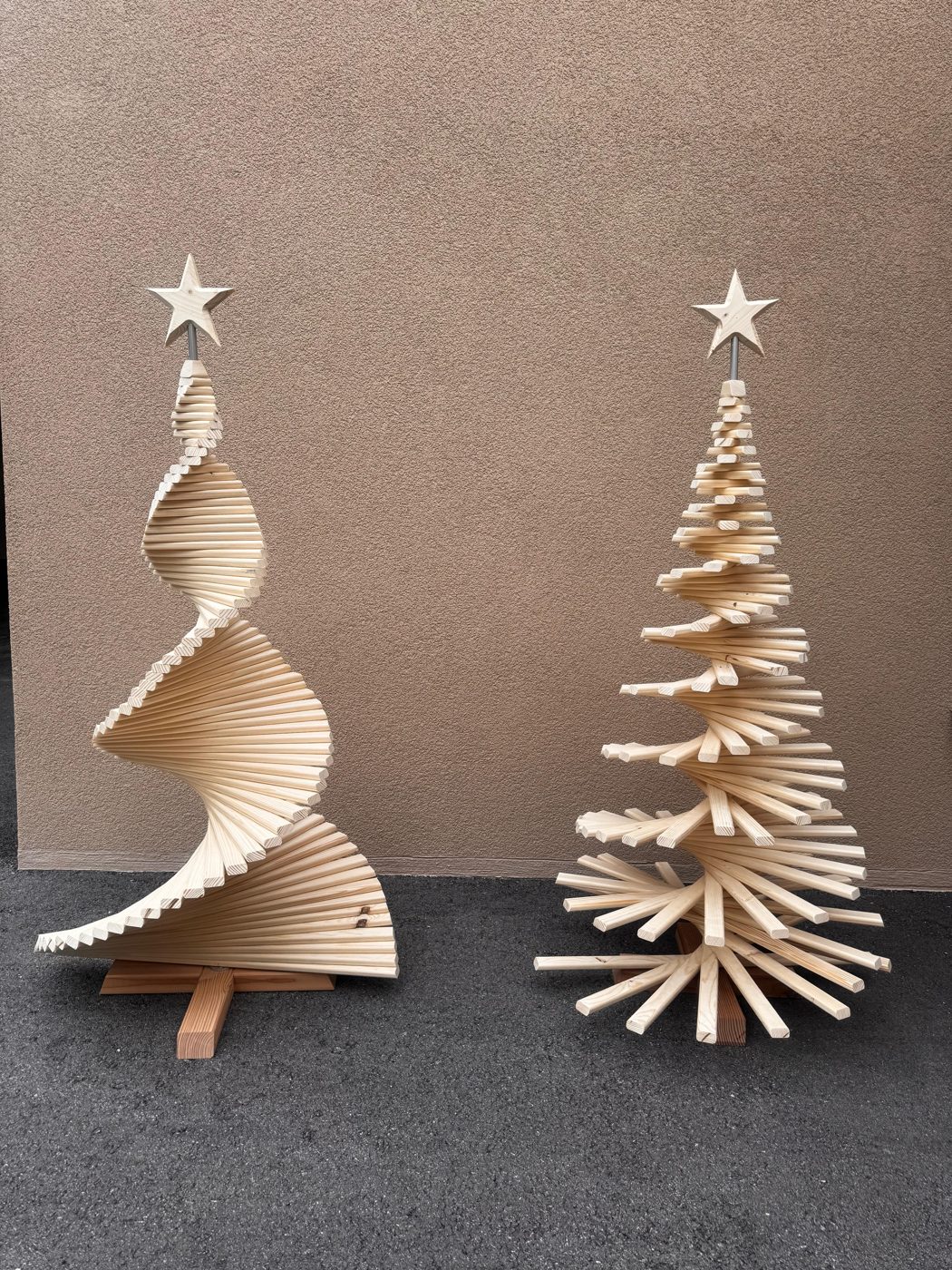 Deux sapins en lattes de bois clair avec étoile : un en spirale, un étagé